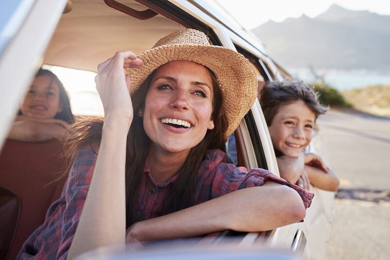 Woman smiling leaning out of car window