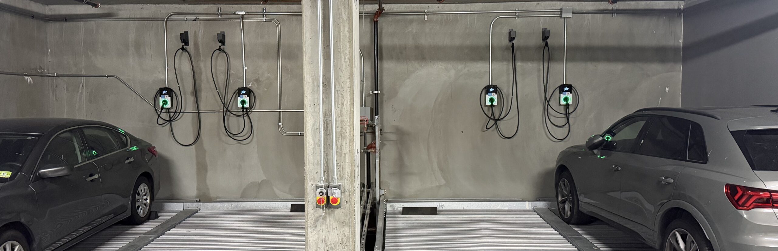 Assigned EV chargers installed in a multi-family parking area, using special car lift equipment.